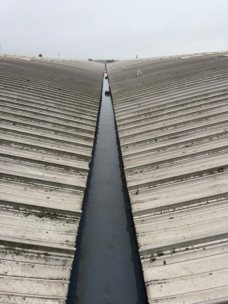 Industrial valley gutter after cleaning on a warehouse roof